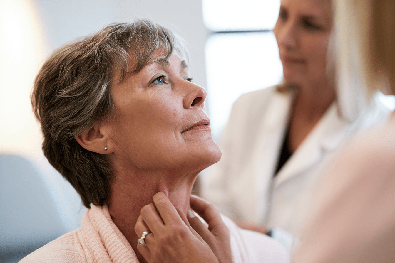 Radiation oncologist examines a mild neck skin reaction during radiation treatment for atc.