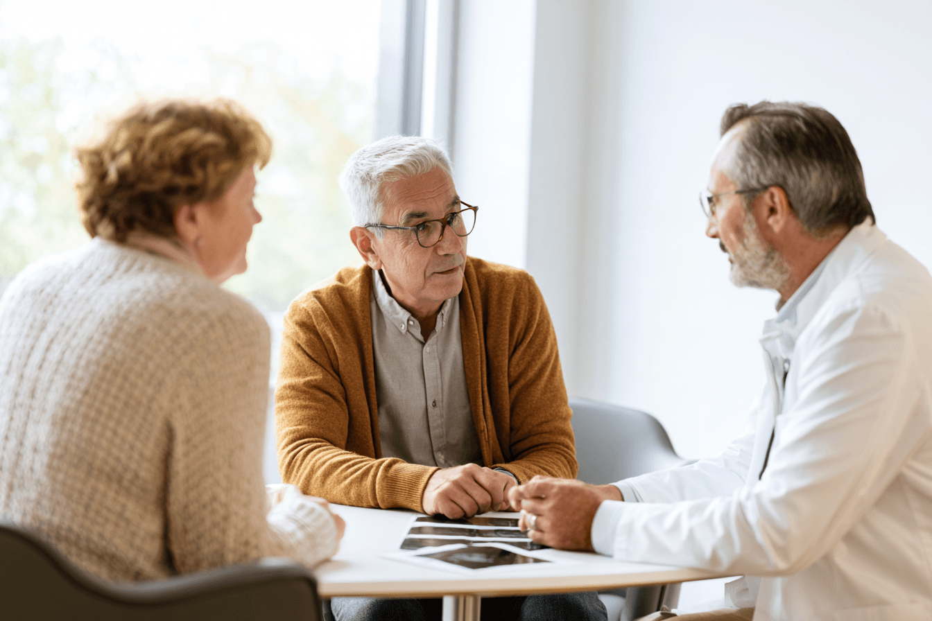 Stage 4 Esophageal Cancer: Symptoms, Survival And What To Expect 1 Doctor discussing medical reports with a patient and companion during an oncology consultation.