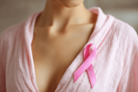 Atypical ductal hyperplasia surgery awareness concept with pink ribbon on woman’s chest