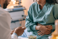 Alfalfa sprout outbreak 2026 patient being examined for e. Coli and salmonella symptoms in a modern hospital.