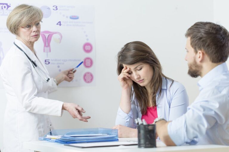 Doctor explaining reproductive health to a couple during infertility consultation showing common causes of female infertility