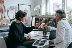 Doctor reviewing MRI scan for desmoid tumor recurrence with a patient in a modern clinic