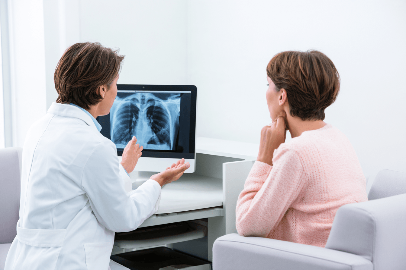 Oncologist explaining chest imaging to a patient during a discussion of cancer staging.