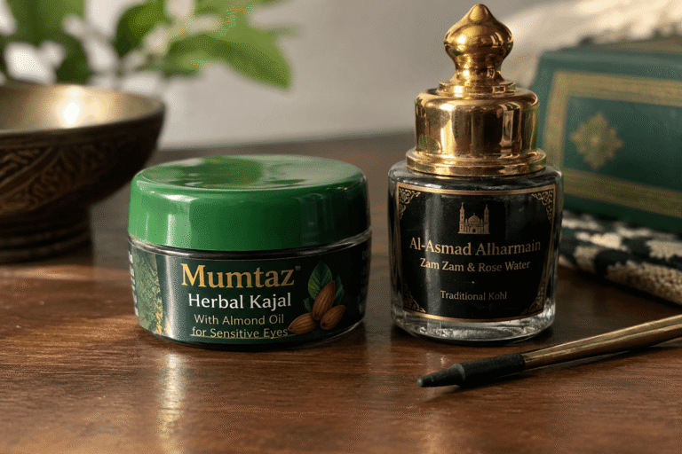 Illustrative kajal and kohl containers with a gold-handled applicator on a wooden table.