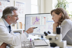 Hematologist explaining leukemia blood test, CBC and blood smear results to a patient during consultation.