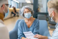 Home 8 Doctor discussing long covid immune dysfunction symptoms including fatigue and brain fog with a patient during a medical consultation.