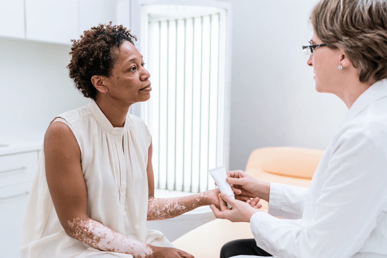 Can Vitiligo Be Cured Permanently? Treatment Results And Ayurveda 3 Dermatologist discussing a cream with a woman beside an inactive phototherapy cabin.